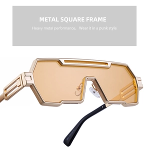 Macro detail of steampunk gold metal sunglasses featuring industrial hollow geometric temples