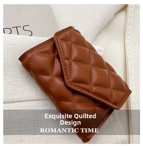 Close-up of brown quilted leather wallet with classic diamond stitching on white fabric