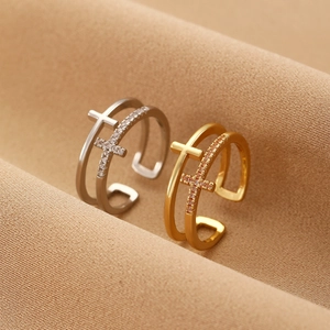 Macro shot of double-layer cross rings in gold and silver finish with crystal inlay