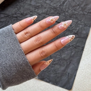 Gros plan d'ongles à presser à imprimé léopard avec fleurs 3D blanches et billes d'or