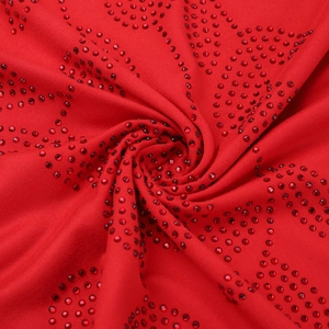 Macro shot of red dress fabric with detailed rhinestone embellishments and texture