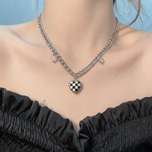 Close-up of Y2K style necklace with checkered heart pendant and clear beads on model