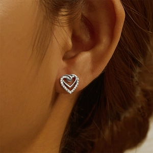 Detailed close-up of S925 sterling silver double heart stud earrings worn by a model