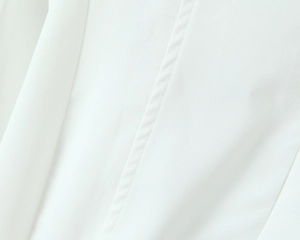 Detailed macro view of pure white fabric texture and vertical stitching on the dress