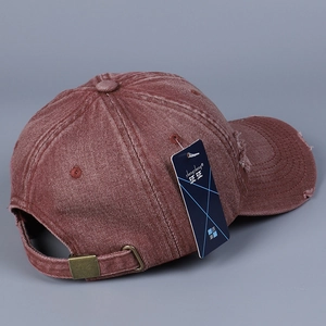 Detail of vintage washed denim baseball cap featuring distressed edges and adjustable metal buckle