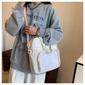 Detail showing white canvas ita bag with transparent front pocket and adjustable strap