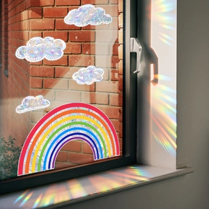 Rainbow and clouds window prism stickers casting vibrant colorful light on a brick wall