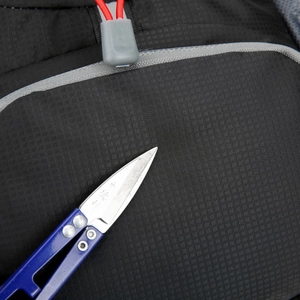 Close-up showing the scratch-resistant nylon fabric of the men's waist bag with scissors