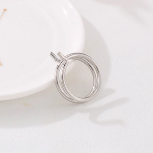 Minimalist double layer silver stainless steel ring displayed on a white porcelain dish