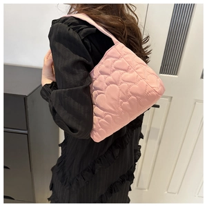 Vue détaillée du sac à main matelassé rose avec motif cœur et texture rembourrée