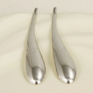 Macro view of teardrop earrings in 304 stainless steel on a white silk background