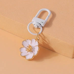 Close-up of white cherry blossom keychain with gold edging and matching metal clasp