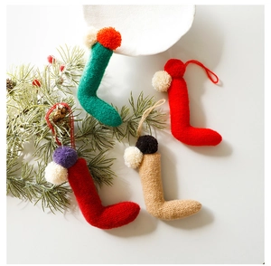 Vista dettagliata di ornamenti a calzino di Natale in maglia colorata con pompon