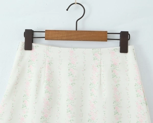 Détail d'une mini-jupe taille haute avec motif floral rose et texture de tissu fine