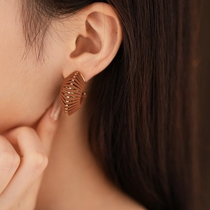 Detail von braunen Kunstleder-Creolen mit elegantem goldenem Metallrahmen für Damen