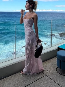 Robe longue élégante en jacquard rose avec fines bretelles présentée sur une terrasse