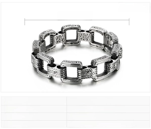 Détail d'un bracelet pour homme en acier inoxydable vintage avec gravures et cristaux