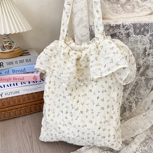 Detail view of floral canvas tote bag with ruffled trim and delicate yellow flower patterns