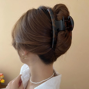 Detailed close-up of large tortoiseshell hair claw clip securing a back-of-head bun
