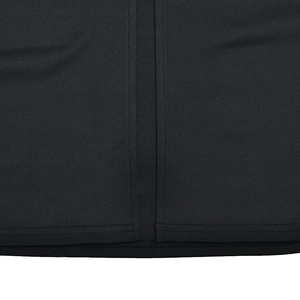 Gros plan sur la texture du tissu noir et l'ourlet à double couture de cette robe chic