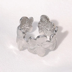 Macro view showing detailed floral pattern and silver finish on stainless steel ring