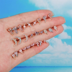 Détail de divers clous d'oreilles sucette et glace rose et violet sur la main