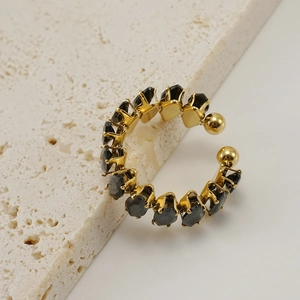 Detailed view of 18K gold plated adjustable ring with black faceted gemstones on stone