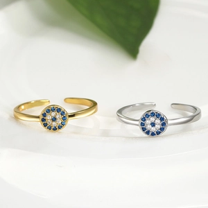 Gold and silver evil eye open rings with blue cubic zirconia on white background