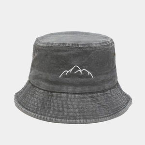 Detailed close-up of mountain peak embroidery on washed denim fisherman hat fabric