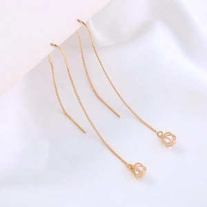 Elegant gold drop earrings with zircon sphere pendants on white silk background