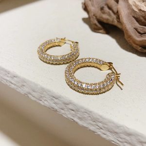 Dettaglio di orecchini a cerchio a U placcati in oro con zirconi bianchi micro-pave