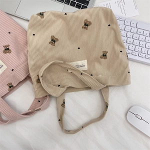 Corduroy tote bag featuring a cute bear print in a cozy office and study setting