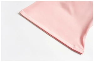 Gros plan détaillé de l'ourlet à double couture sur le débardeur de yoga rose brossé