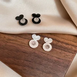 Elegante herzförmige Acryl-Ohrstecker in Schwarz und Perlweiß mit transparenten Verschlüssen