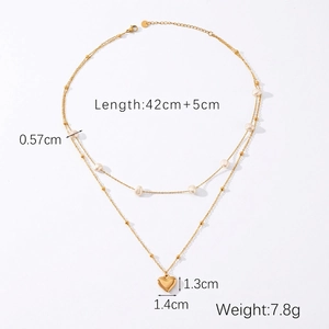 Detail showing gold heart pendant and pearl accents on a double-layer stainless steel necklace