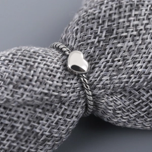 Vintage S925 silver heart ring with twisted rope design on grey linen background