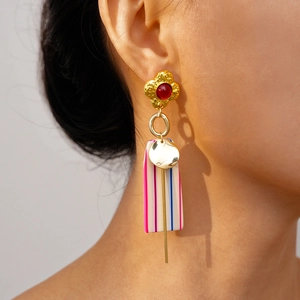 Close-up of geometric resin drop earrings with floral relief and colorful stripes