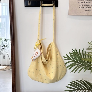 Close-up of yellow checkered canvas shoulder bag with a cute white duck pendant charm