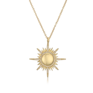 Detail view of a gold-plated sunburst pendant with sparkling white cubic zirconia stones