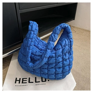 Quilted bright blue puffy tote bag with soft padded texture and spacious shoulder straps