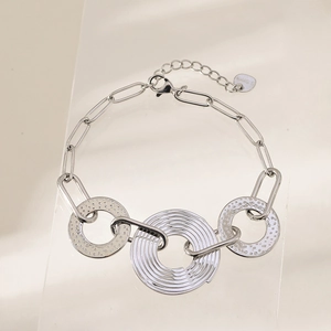 Close-up of silver stainless steel chain bracelet with textured circular pendants and S.Steel tag