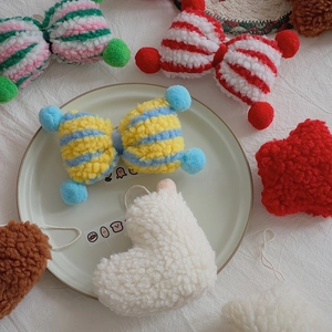 Detailed view of colorful lamb wool plush ornaments in bow and heart shapes