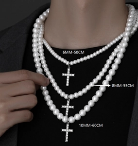 Three sizes of layered pearl necklaces with cross pendants shown on a model
