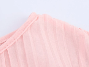 Macro view of pink pleated chiffon fabric detailing fine stitching and airy texture