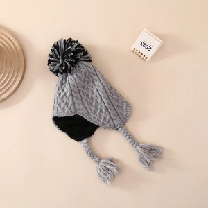 Close-up of grey knitted baby hat featuring warm fleece lining and braided earflaps
