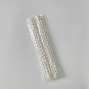 Detail view of two beige handmade bohemian cotton rope curtain tiebacks in packaging