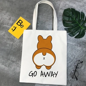Flat lay of a white canvas tote bag with a cute Corgi print and 'GO AWAY' text