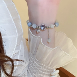 Detailed view of beaded bracelet with blue stones, star charm and purple gemstone accent