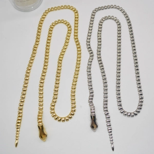 Detailed view of articulated gold and silver snake chains with scales and snake head tips