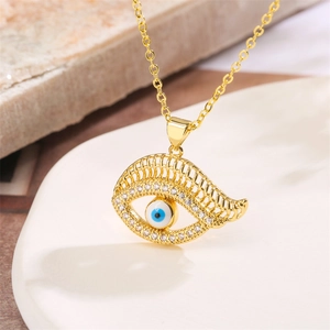 Macro shot of evil eye pendant with blue crystals on fine gold chain necklace